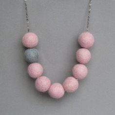 a necklace made out of felt balls on a chain