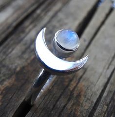 Handmade, Natural Rainbow Moonstone Sterling Silver Ring 💙Featured in this listing are sterling silver, handmade, natural stone rings. These lovely rings feature a beautiful, Natural Rainbow Moonstone 7mm round stone. The Glowing stone has been bezel set into a handcrafted, adjustable setting made with all highly polished Sterling Silver. A handcrafted Crescent Moon sits aside the Moonstone and is 11x15mm. Each Rainbow Moonstone has been handpicked, and have amazing flash! 🌜Please keep in mind Silver Moonstone Crystal Ring In Moon Shape, Silver Moonstone Ring With Moon Phase, Mystical Moon-shaped Moonstone Ring In Sterling Silver, Silver Moon Phase Crystal Ring, Mystical Moon-shaped Sterling Silver Moonstone Ring, Spiritual Crescent Moonstone Ring, Silver Moon-shaped Moonstone Ring Gift, Mystical Sterling Silver Moonstone Ring With Moon Phase, Bohemian Sterling Silver Moon-shaped Crystal Ring