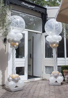 some white and silver balloons are in front of a building