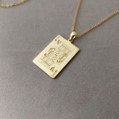 a gold necklace with an image of a cat on it