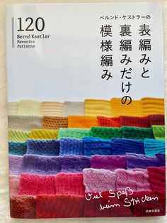 a book with chinese writing on it and colorful towels in the front, sitting on a white surface