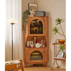 a small wooden cabinet in the corner of a room next to a table and chair