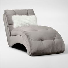 a gray chaise lounge chair with a white pillow on it's backrest