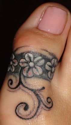 a close up of a person's hand with a flower tattoo on their thumb