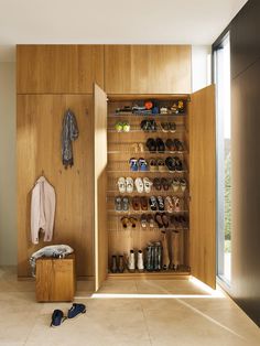 a wooden closet with clothes hanging on it