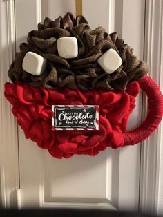 a wreath with marshmallows and chocolate on it hanging from the front door