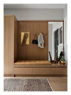 a wooden bench sitting under a mirror in a room