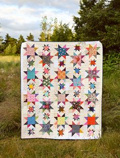 a quilt is on the grass in front of some trees