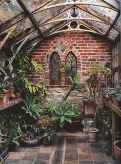 the inside of an old brick building with potted plants