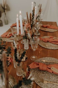 a wooden table topped with plates and candles