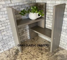 a white vase sitting on top of a wooden shelf next to a wall with bricks