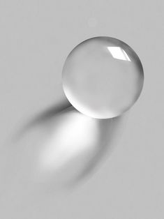 an image of two white balls on a gray surface with light coming through the top