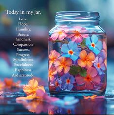 a jar filled with pink and blue flowers on top of a table next to a poem