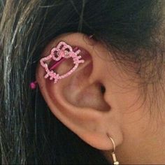 an ear with a pink hello kitty pin attached to it's back end,