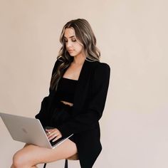 a woman sitting on a chair using a laptop computer