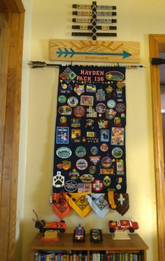 a bulletin board covered in stickers and magnets next to a bookshelf