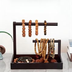 an assortment of beads are displayed in a wooden display case on a marble countertop