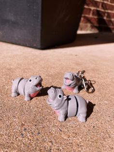 two small toy hippos are on the ground