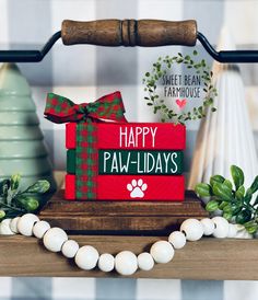 a red box that says happy paw - holidays with a green bow on it and a dog's paw next to it