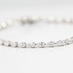 A show-stopping tennis bracelet, sparkling marquise diamonds linked end-to-end fall delicately against the wrist. An accessory made to flatter, the Marquise Tennis Bracelet is a charming addition to any occasion. Pictured with the Emerald and Pear Lab Grown Diamond Tennis Bracelets. Details: 6.5 inches long 14k white, yellow, or rose gold 6.4ct total weight- lab-grown diamonds *all diamonds are F-G color, VS1 clarity or better Bracelet has a safety clasp. Classic Marquise Diamond Bracelet With Brilliant Cut, Classic Marquise Diamond Bracelet In White Gold, Marquise White Gold Tennis Bracelet With Diamond Accents, Classic Marquise White Gold Diamond Bracelet, Marquise Diamond Accent Bracelets For Anniversary, Fine Jewelry Pear-shaped Diamond Bracelet For Wedding, Wedding Fine Jewelry Diamond Pear-shaped Bracelet, Pear-shaped Diamond Bracelet For Weddings, Fine Jewelry Pear-shaped Bracelets With Diamond Accents