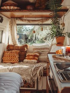 the interior of a camper with lots of pillows and blankets