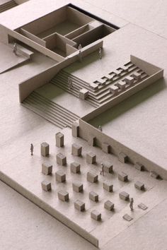 an architectural model of a building with many small objects on the floor and in front of it