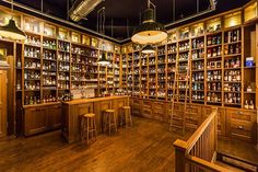 a room filled with lots of bottles and stools in front of wooden shelves full of liquor