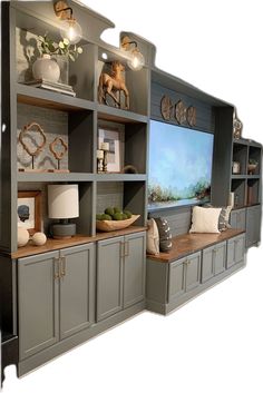 an entertainment center with gray cabinets and white lamps