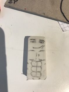 a piece of paper with writing on it next to a pencil and eraser in the shape of a woman's face