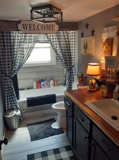 a bathroom that has a welcome sign above the bathtub and sink in front of it