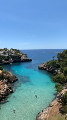 people are swimming in the clear blue water