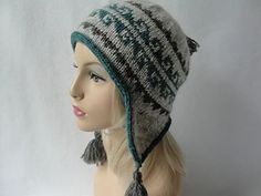 a mannequin head wearing a knitted hat with tassels