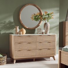 a wooden dresser sitting next to a mirror and vase with flowers on top of it