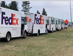 several fed ex trucks parked in a row