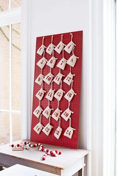 a red and white calendar hanging on a wall next to a table with some candy