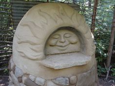 a stone oven with a face carved into it