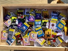 a wooden box filled with lots of different types of keychains and magnets