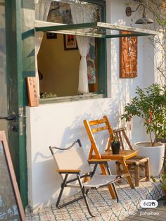 two chairs and a table on the outside of a house