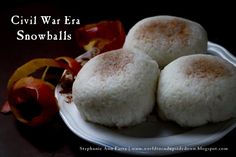 three small white snowballs on a plate next to some autumn leaves and an orange flower