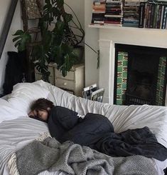 a person laying on top of a bed covered in blankets