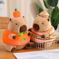 two stuffed bears sitting on top of a table next to each other holding carrots