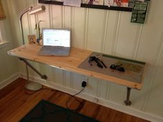 a laptop computer sitting on top of a wooden desk next to a lamp and mouse