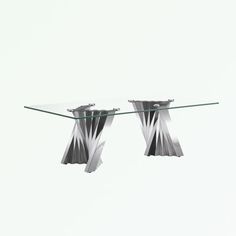 a glass table with two silver vases on it and one is upside down in the air