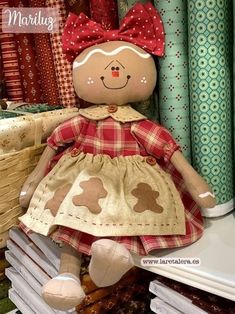 a teddy bear with a red bow on it's head sitting in front of many folded books