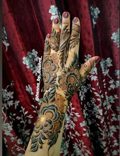 a woman's hand with henna tattoos on it