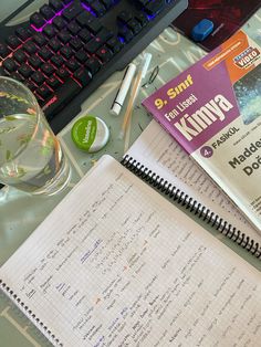 an open notebook sitting on top of a desk next to a keyboard