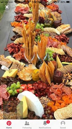 a long table filled with lots of different types of cheeses and crackers on it