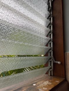 a wooden bench sitting next to a window covered in frosted glass covering it's sides