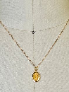 14k solid yellow gold St. Christopher small oval medallion pendant. 14mm (includes measurement of attached ring x 8mm wide. Displayed from a 14k solid gold 16 inch cable  1.5mm chain. Even though this is a smaller delicate chain it's substantial enough to wear alone without the pendant. Total gold weight 1.4 grams. This a smaller pendant that I paired with a 16 inch necklace. If you would like a longer necklace or heavier necklace I have several available in my shop. I can add your pendant to any necklace of your choosing. Message me for prices, length and styles. Please email me if you any questions about this listing or any of my other listings. I will get back to you with-in the day. It helps to take a ruler and use the measurements as a comparison. Item's pictures are enlarged and zoom Gold Engraved Oval Cabochon Necklace, Oval Charms Jewelry For Memorial, Gold Oval Jewelry With Adjustable Chain, Gold Oval Charm Necklace With Adjustable Chain, Yellow Gold Oval Charm Necklace With Adjustable Chain, Yellow Gold Charm Necklace With Oval Coin Pendant, Classic Oval Coin Pendant Necklace, Gold Oval Pendant Charm Necklace For Anniversary, Gold Oval Charm Necklaces