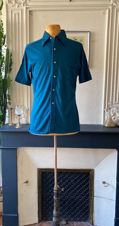 Vintage 70s men's blouse in dark turquoise color, with short sleeves and rigid lapel collar, one chest pocket, in cotton blend jersey, soft and slightly stretchy t-shirt feel fabric. Like new vintage condition; DooWop loves its beautiful deep color, its slightly fitted Polo cut and its comfort. Ideal T S/M, please refer to the dimensions below Flat measurements: Shoulders 37.5 cm/14.6 inches Underarms 51.5 cm/20.2 inches Size 47.5 cm/18.5 inches Length 65.5 cm/25.6 inches Blue Cotton Johnny Collar Short Sleeve Shirt, Blue Cotton Short Sleeve Johnny Collar Shirt, Blue Cotton Short Sleeve Shirt With Johnny Collar, Fitted Summer Polo Shirt With Pockets, Fitted Polo Shirt With Pockets For Summer, Vintage Summer Polo Collar T-shirt, Blue Cotton Johnny Collar Shirt, Vintage Blue Collared T-shirt, Blue Cotton Shirt With Johnny Collar